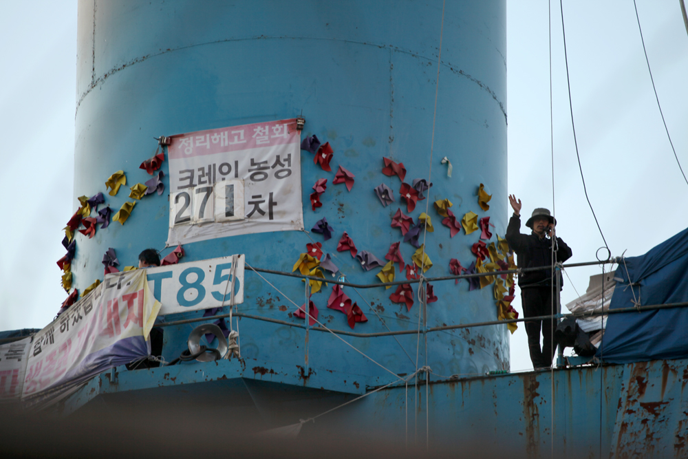 '85 크레인 김진숙'을 사수하기 위해 한진 중공업 해고 노동자 정흥영, 박영제, 박성호씨가 113일째 (10월 17일 현재) 농성을 이어가고 있다. 사진은 박영제씨가 건너편에 선 아내와 통화하는 모습 (Photo @ Lee Yu Kyung)