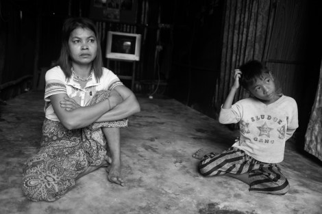 Chan Chao Loy (or ‘Loy’) and his mother at home. Loy's mother is waster picker as well working from 11pm till early morning. The family used to live at a rent house for which they paid 30 dollars monthly. However, they couldn’t afford the rent but had to move illegally built shacks’ touted neighborhood 3 years ago, where most of dwellers are waste pickers. (Photo © Lee Yu Kyung 2013) 