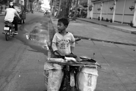 Chan Chor Loy (or 'Loy'), a 12 year old waster picker in Cambodia, is looking at opposite side of the road as he found a huge rubbish bin, in which he must have expected lots of recycling materials. (Photo © Lee Yu Kyung 2013) 