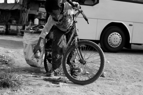Chan Chor Loy (or ‘Loy’), a 12 year old waster picker in Cambodia, is throwing remains of can, after which he wants to add the empty to his collecting recycling materials. (Photo © Lee Yu Kyung 2013) 
