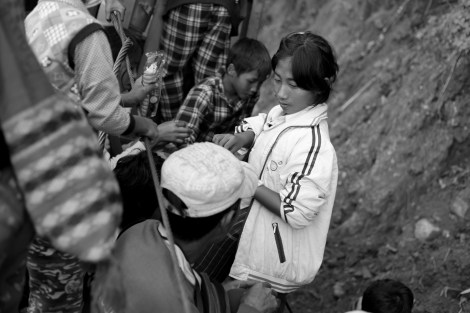 The fleeing Kachin IDPs bumping along a cliffside dirt road in the back of a rickety truck. (Photo © Lee Yu Kyung 2013)