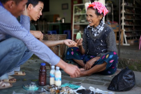 Lisu woman is trying to sell jade to Chinese men in Laiza. The one she’s holding up costs 1,000 CNY ($160 USD). Jade is one of affluent natural resources in Kachin state, which are said to be partly factor of the ongoing conflict.  (Photo © Lee Yu Kyung)