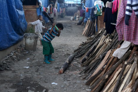 Kachin IDP boy cut wood for fire.  Since the war broke out in Kachin state in 2011, more than 100,000 people have been displaced. (Photo © Lee Yu Kyung)