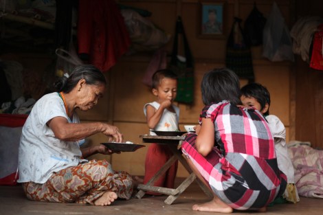 IDPs family is having dinner. The man in the picture on the wall is father of the children. He was killed in the battle field with government troops. (Photo © Lee Yu Kyung)