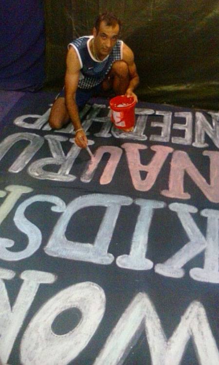 나우루 감호소에 갇힌 이란난민 신청자 라자가 고공농성에 앞서 방대한 천에 메시지를 쓰고 있다. (Photo courtesy : Refugee Action Coalition)