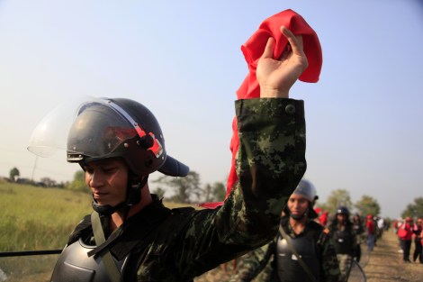 A soldier waving a red scarf as the unit was withdrawing from crowds of Red Shirt protesters in 2010. Thailand is one of more than 30 countries on earth implementing conscription. Many of conscripts are said to be from country's north east where many of Red Shirts are hailed. (© Lee Yu Kyung) 