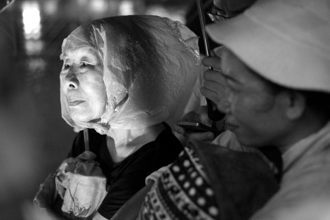 Outstandingly, many of participants in anti-coup rally are middle-aged men and women. The woman in the picture was taking shelter from rain © Lee Yu Kyung 2016