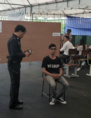 8월 7일 방콕 남동부 방나 지역 한 투표소에서는 ‘No Coup’가 적힌 티셔츠를 입고 나타난 유권자 피야랏 총텝씨가 자신의 투표용지를 공개적으로 찢으며 “독재자는 물러가라. 민주주의 만세”를 외쳤다. 그의 항의투표 행위 후 경찰이 그의 신분증을 보고 있다. (Source : Facebook) 